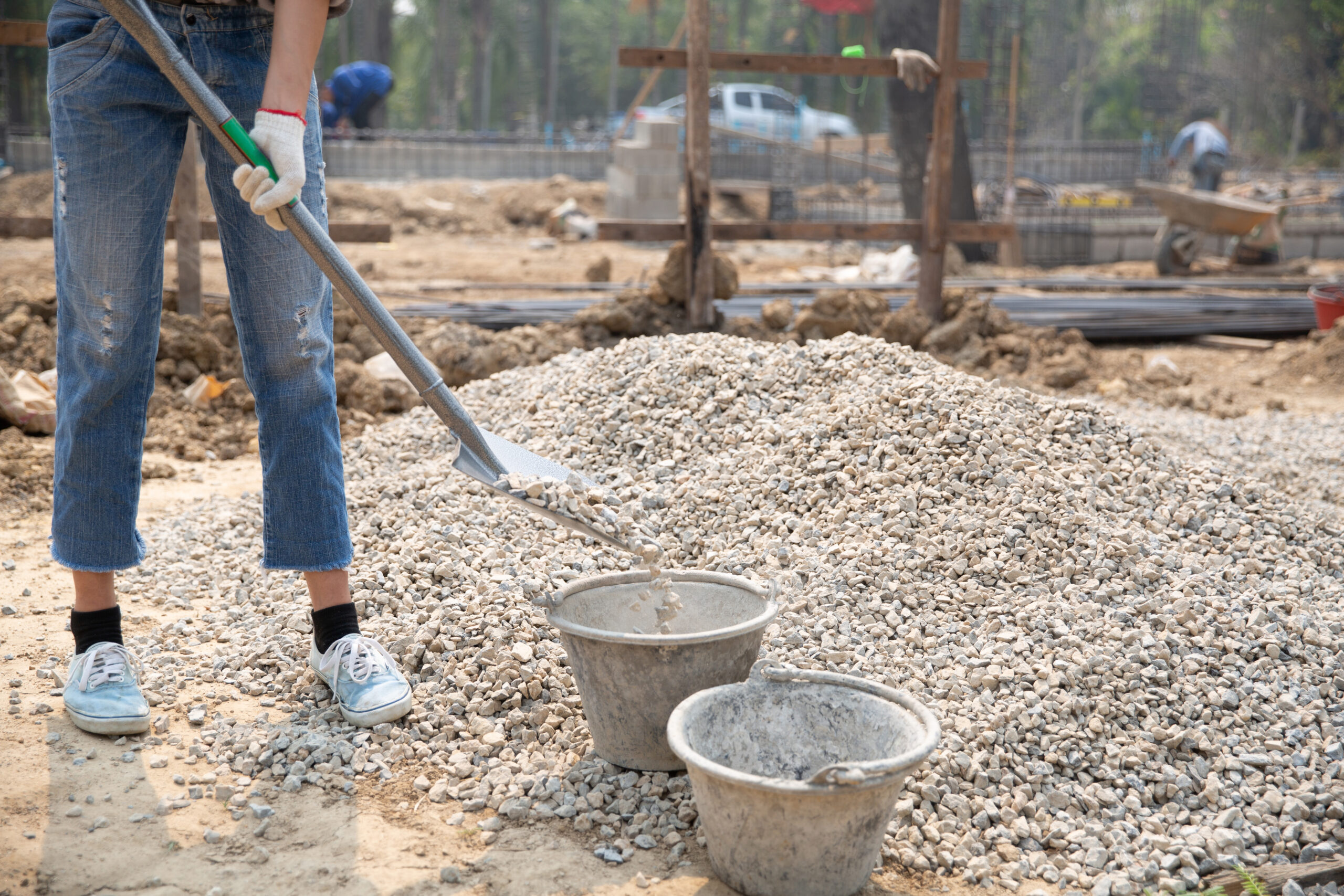 Construction workers carrying a shovel to the construction site